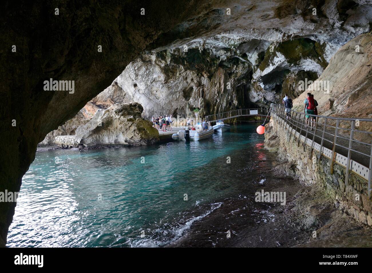 Tourists approaching the entrance to Grotta del Bue Marino limestone caves complex, Gulf of Orosei, Gennargentu National Park, Cala Gonone, Sardinia. Stock Photo