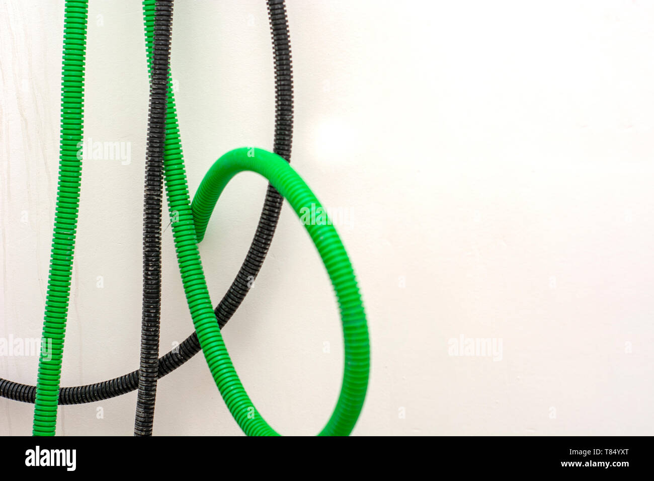 Black and green corrugated bellow conduit tube for electrical wiring Stock Photo