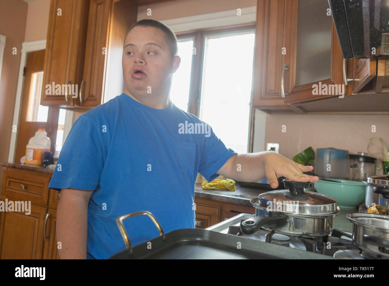 Teen boy with Down Syndrome cooking Stock Photo