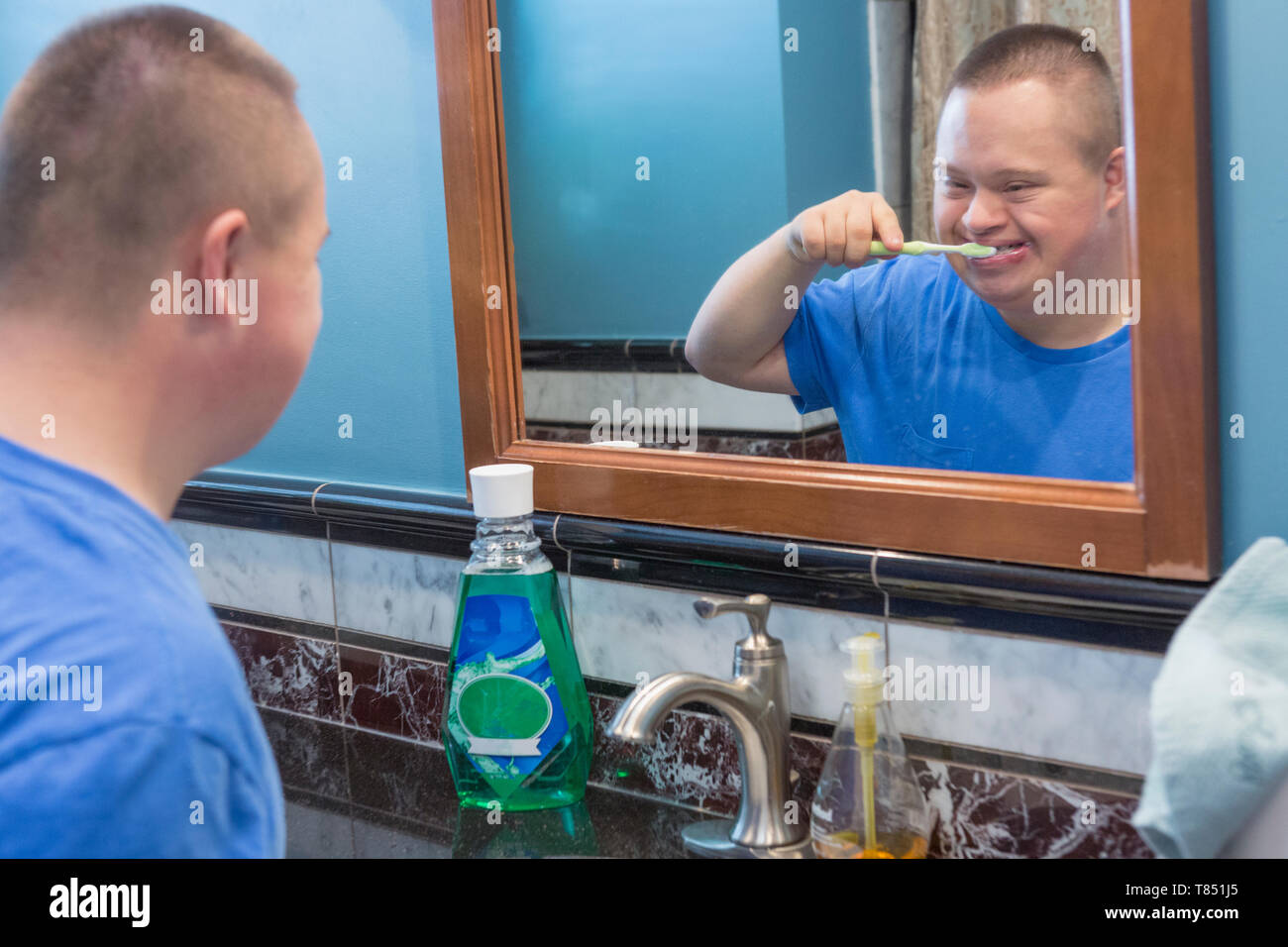Teen with Down Syndrome brushing his teeth Stock Photo