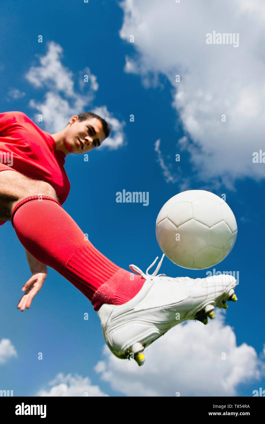 Soccer player kicking ball Stock Photo