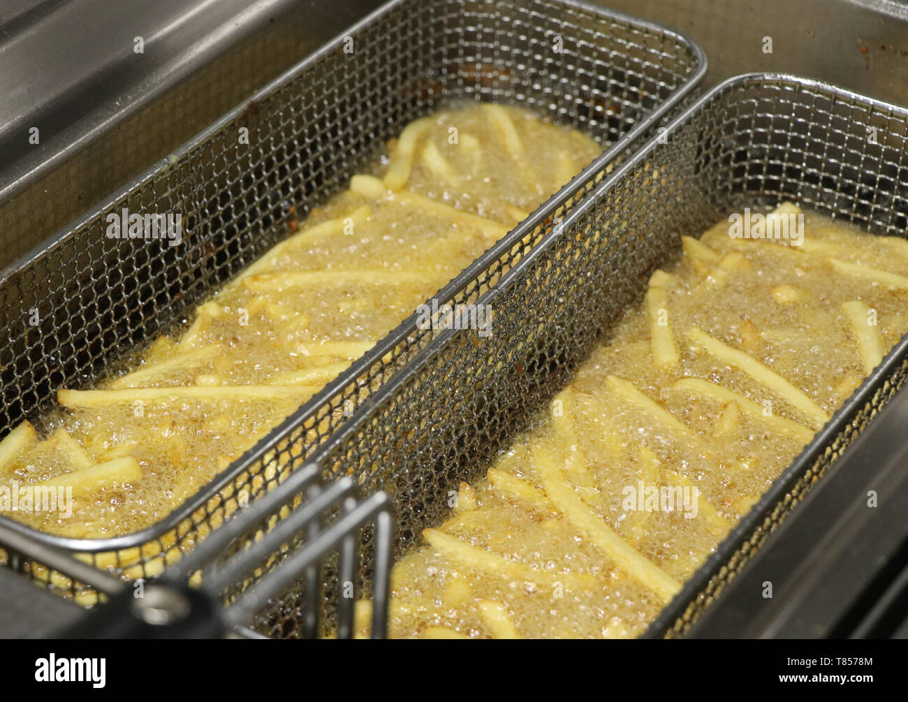 potato chips frying in a deep fryer Stock Photo Alamy