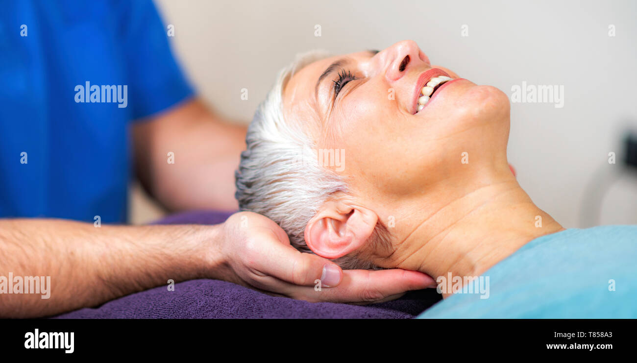 Physical therapist stretching senior woman's neck Stock Photo Alamy