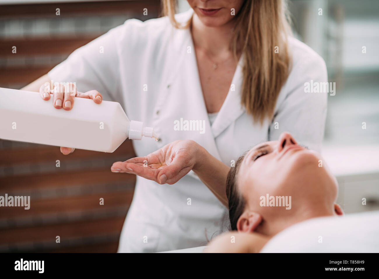 Physical therapist massaging female patient Stock Photo