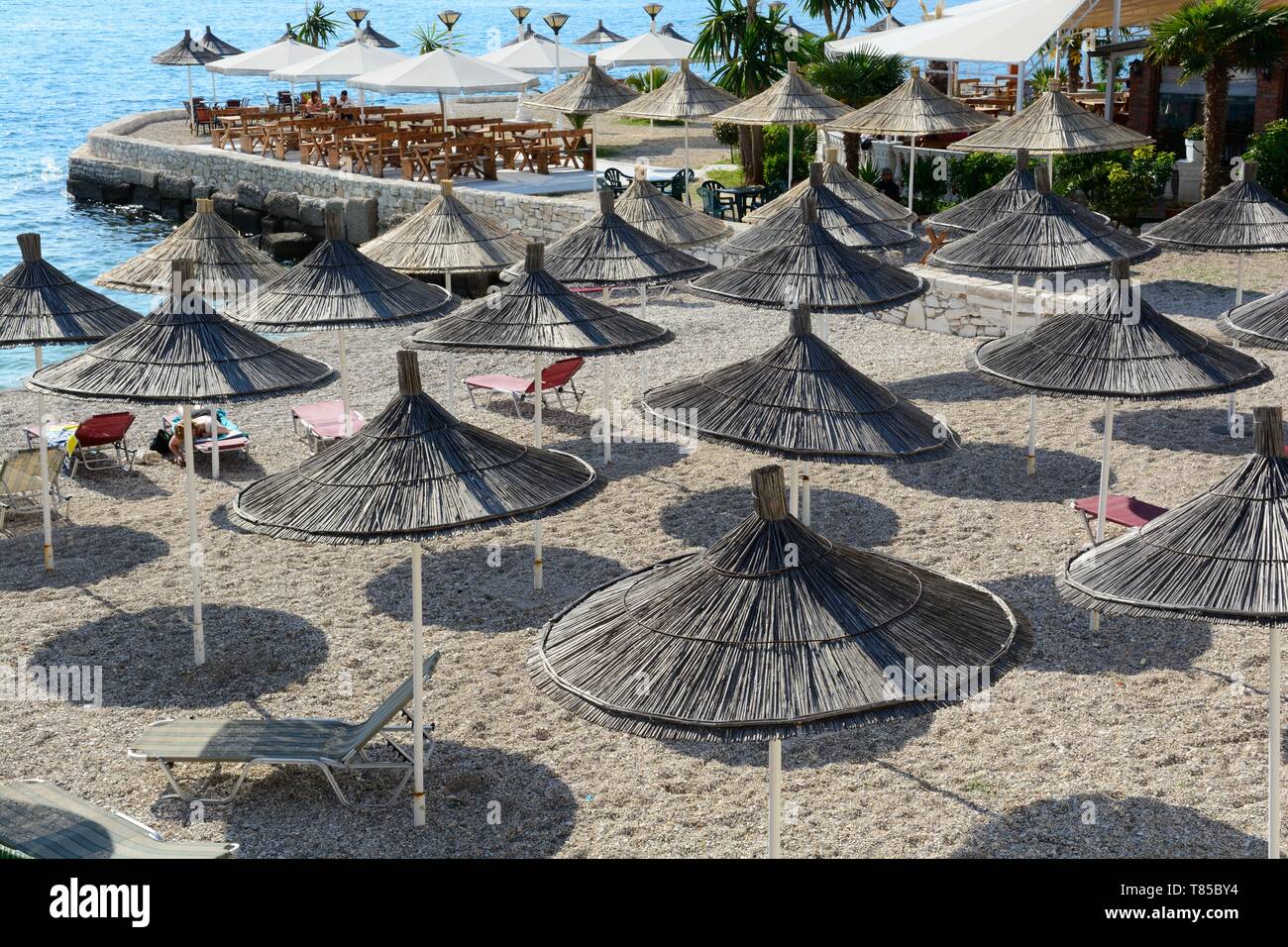 Straw umbrellas parasoles on the beach at Saranda Ionian sea Albania Stock Photo