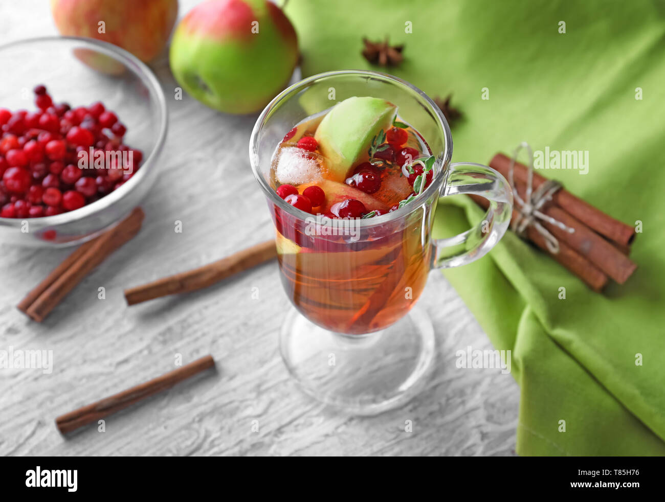 Beverage with apples and cranberry in glass cup on wooden table Stock Photo