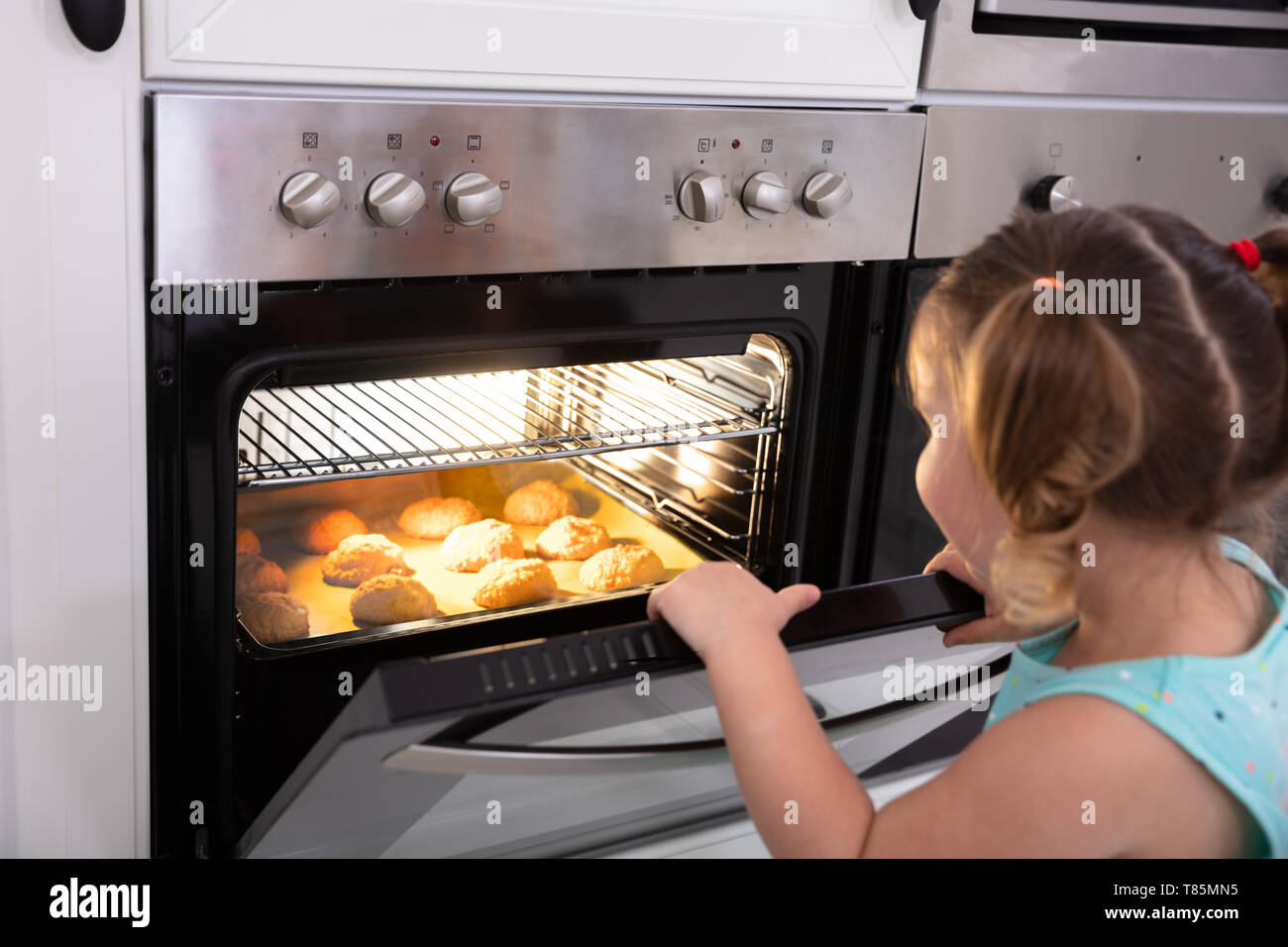 Smiling Little Girl Baking Cookies In Oven At Home Stock Photo Alamy