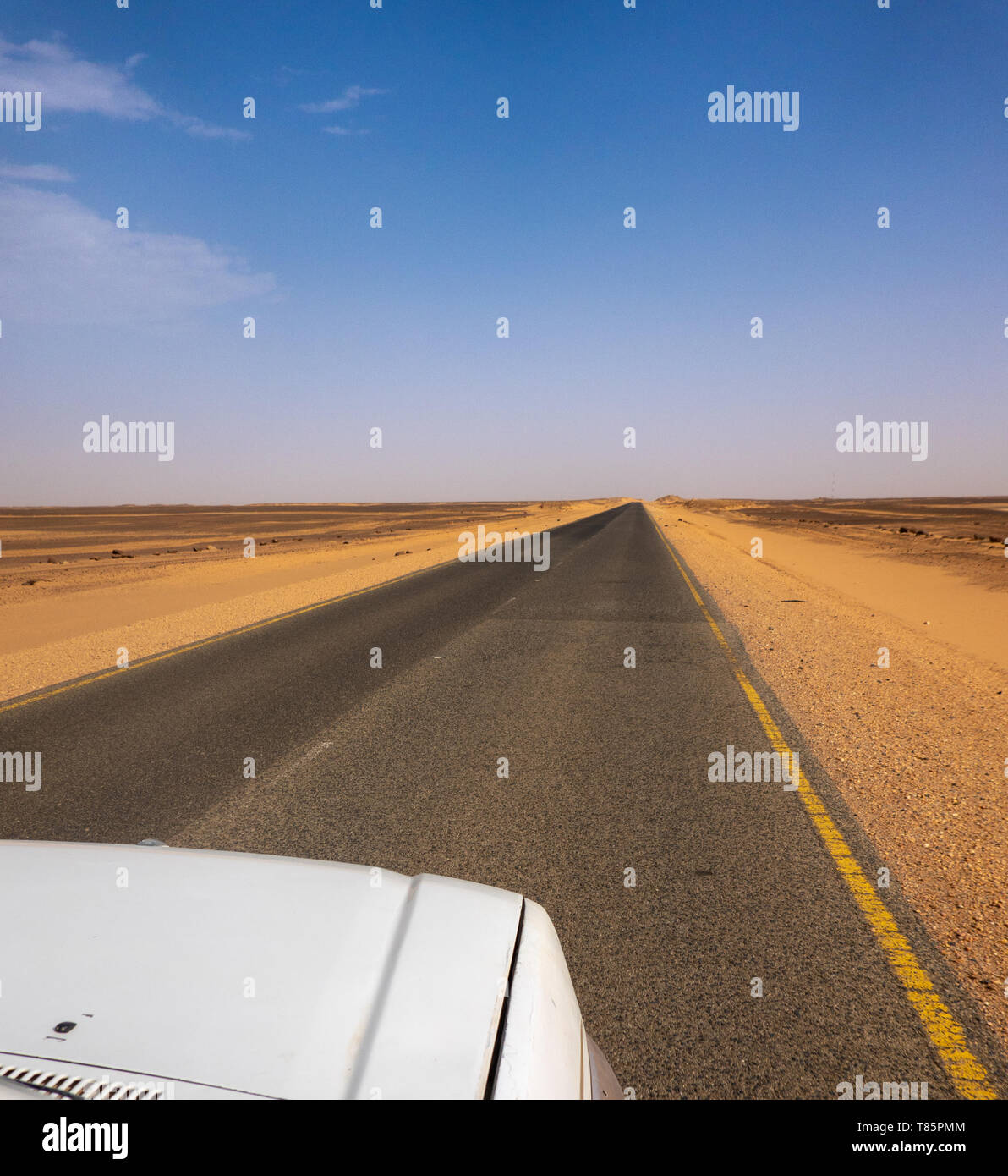 Straight as a die, grey asphalt road through the desert of Sudan- Stock Photo