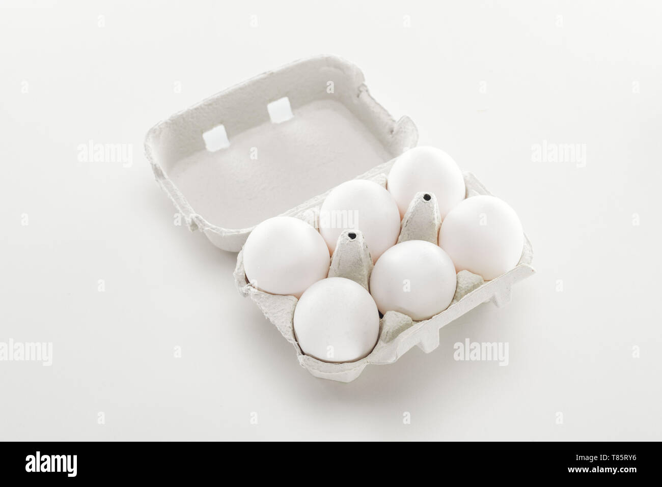 raw white chicken eggs in cardboard box on white background Stock Photo ...