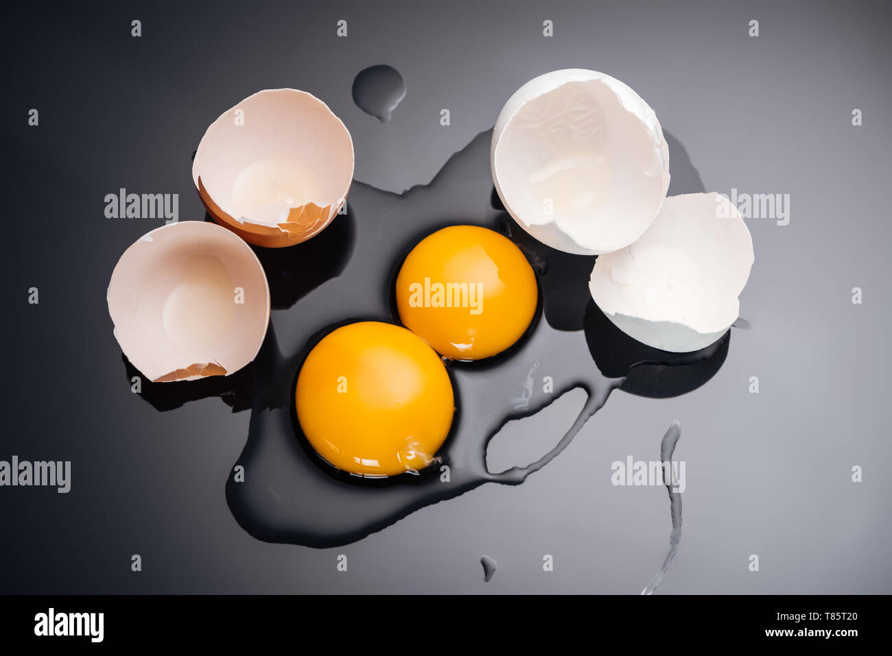 top view of raw smashed chicken eggs with yolks, proteins and eggshell