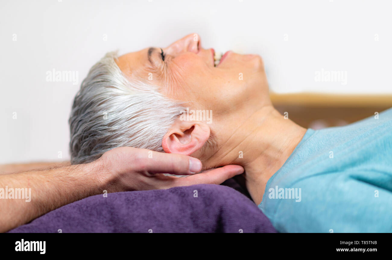 Physical therapist stretching senior woman's neck Stock Photo Alamy