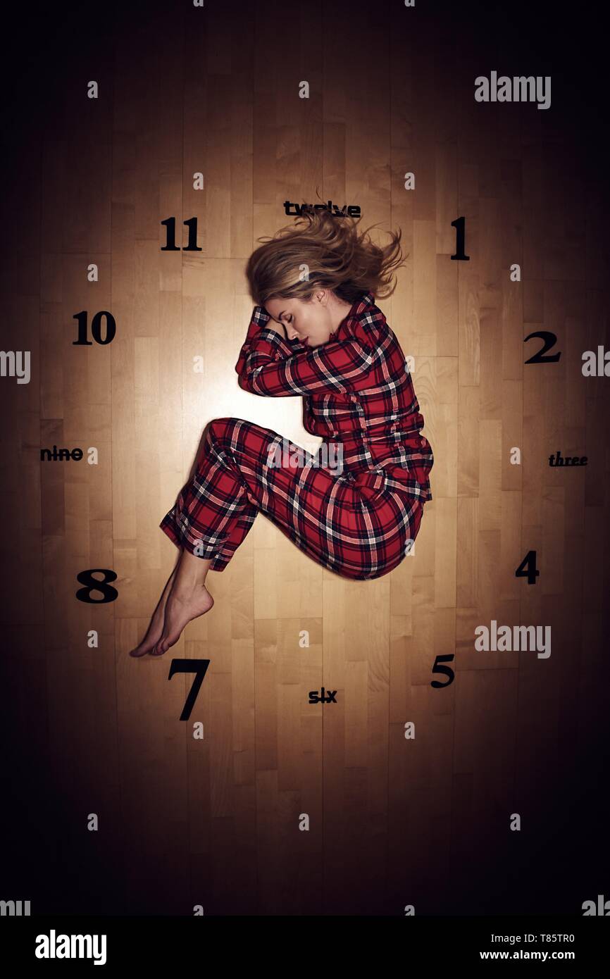 Woman sleeping on clock Stock Photo