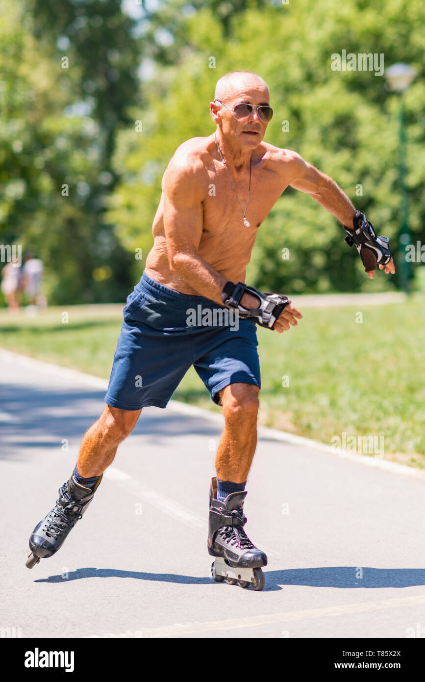 Senior man roller skating in park Stock Photo