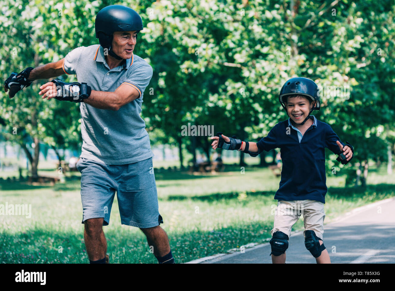 Grandfather and grandson roller skating Stock Photo