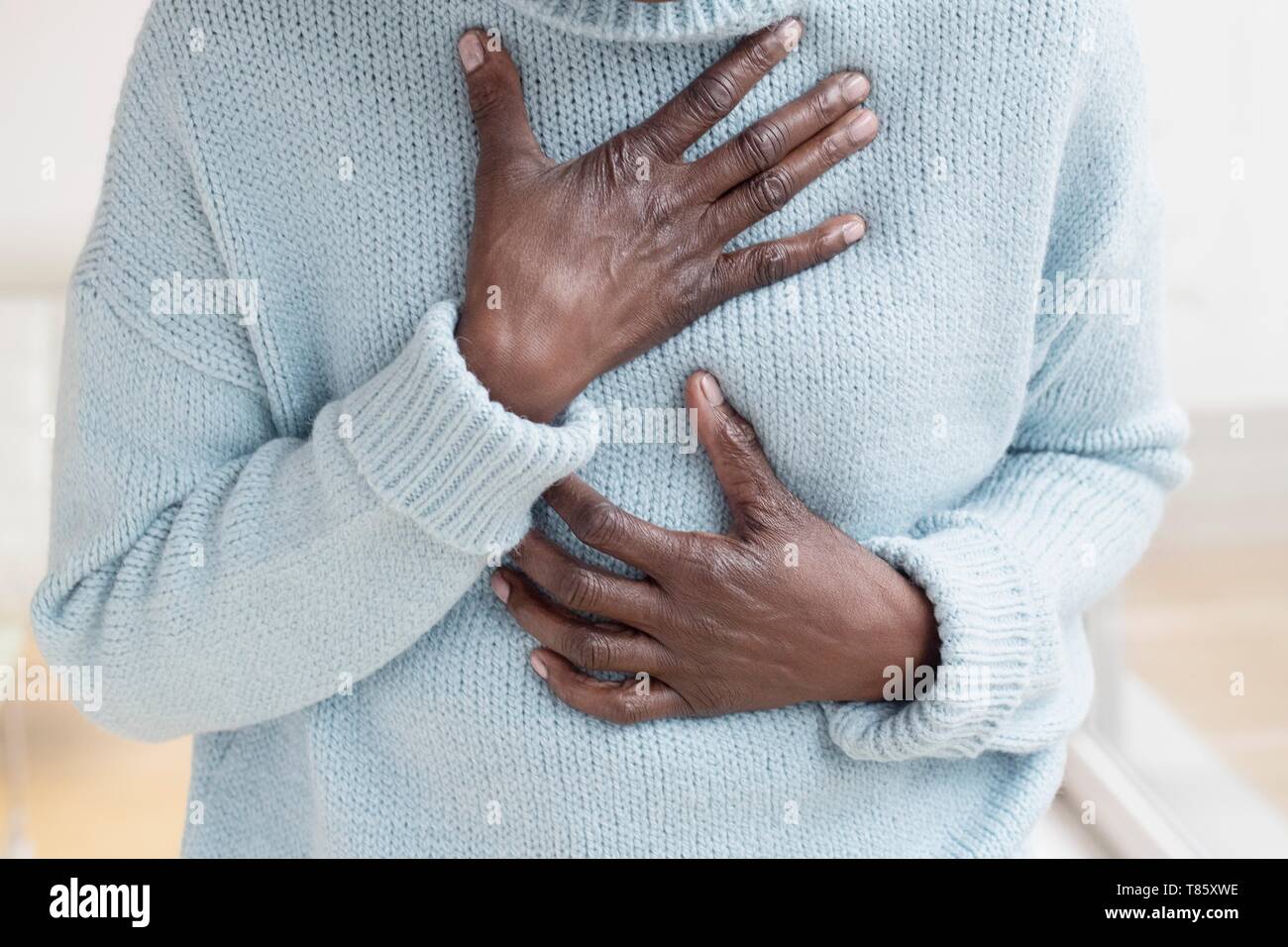Woman touching chest in pain Stock Photo
