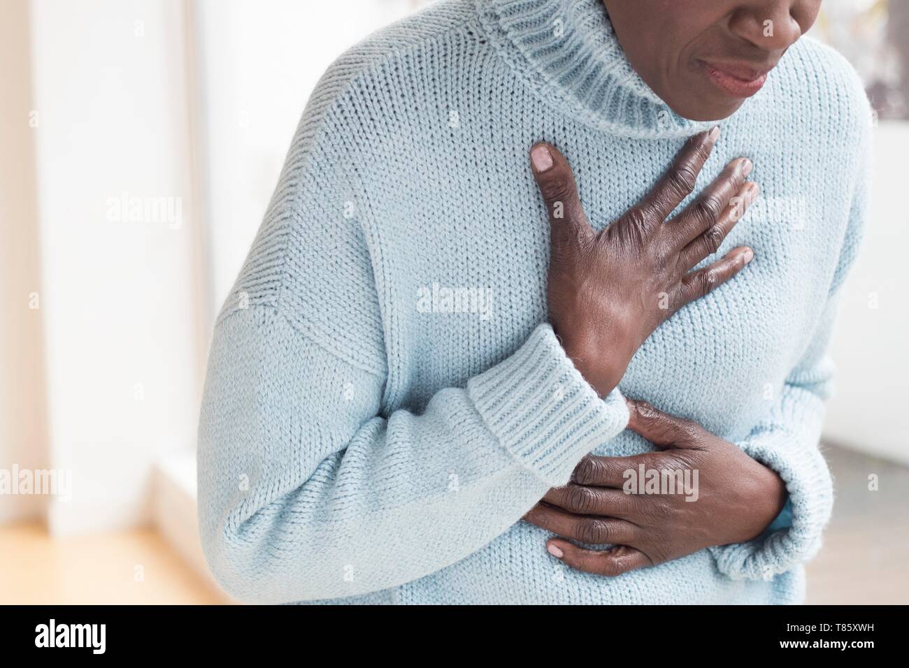 Woman touching chest in pain Stock Photo