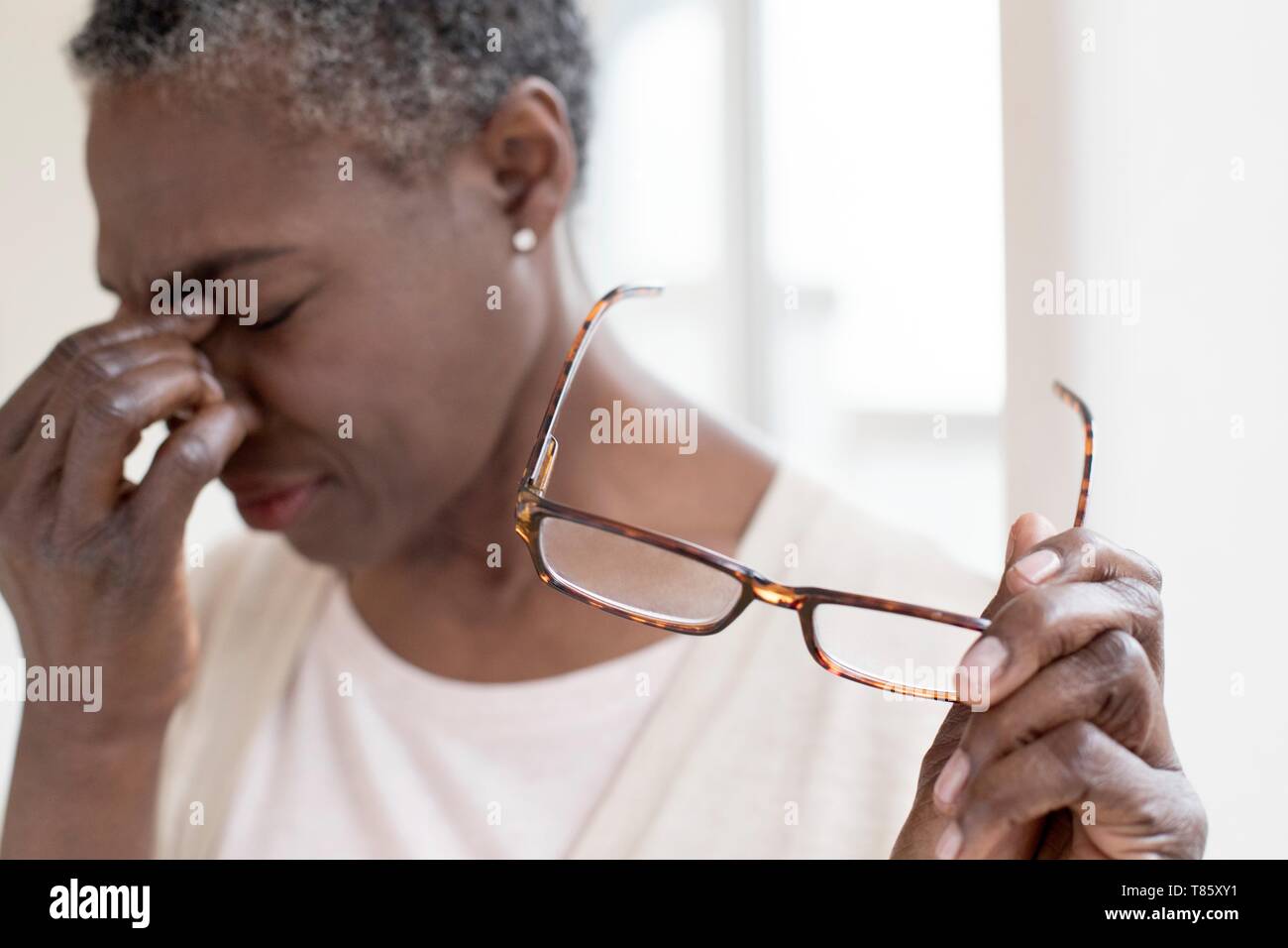 Woman touching bridge of nose Stock Photo