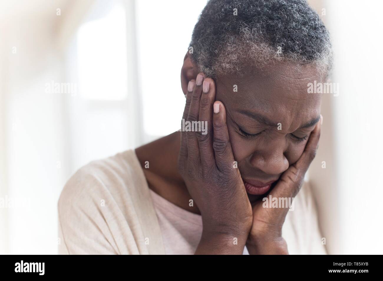 Woman with head in hands Stock Photo