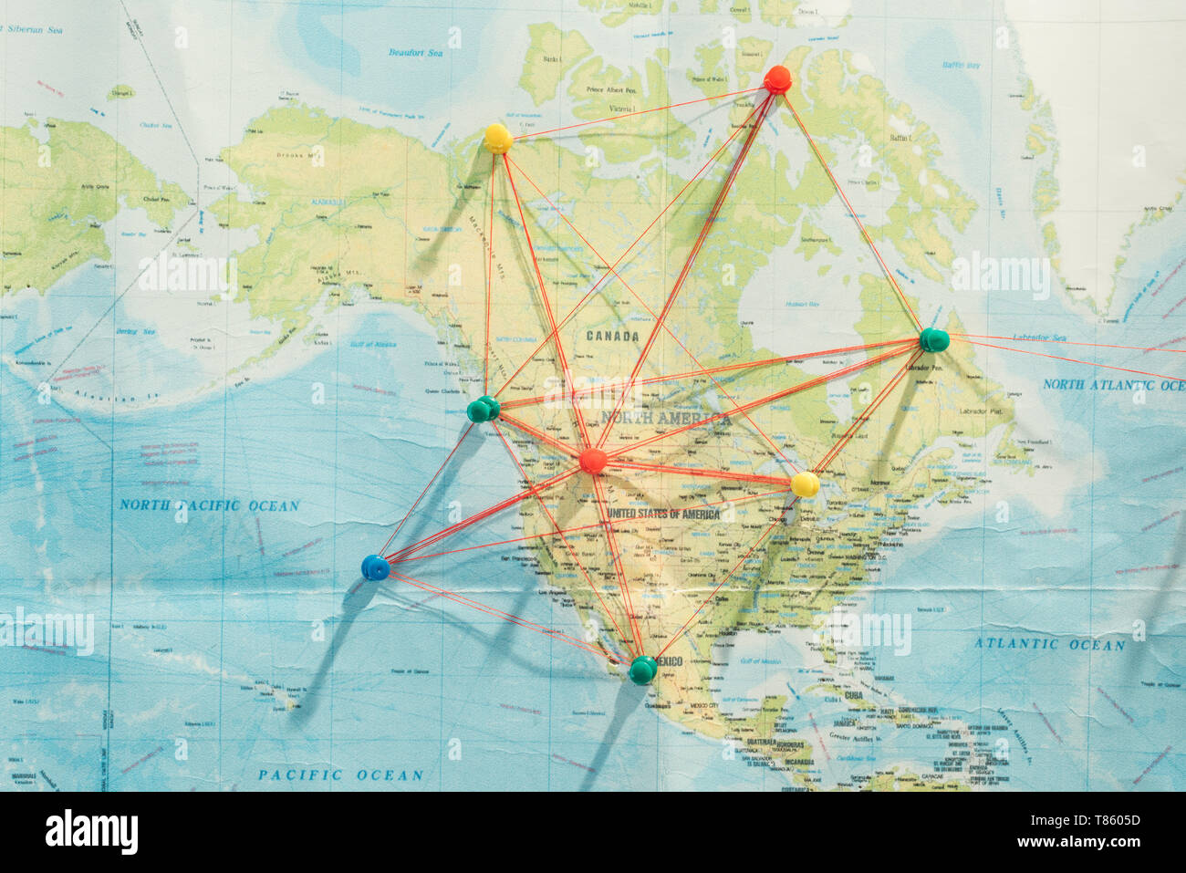 Top view of push pins and strings on world map Stock Photo - Alamy