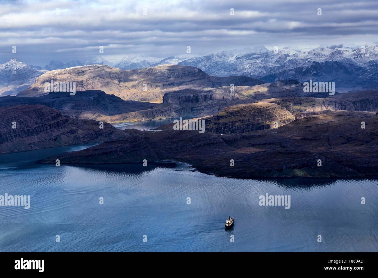 France, French Southern and Antarctic Lands, Kerguelen Islands, Rallier du Baty Peninsula, Baie de la Table, the Marion Dufresne (supply ship of French Southern and Antarctic Territories) at anchor for supplying huts by helicopter. In the background the snow-capped mounts of the Rallier du Baty Peninsula (aerial view) Stock Photo