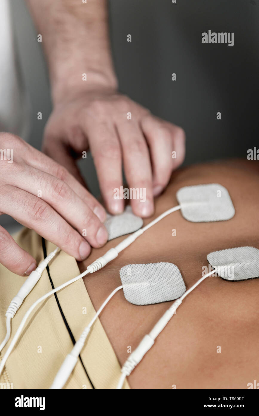 Placing TENS electrodes on upper back Stock Photo Alamy