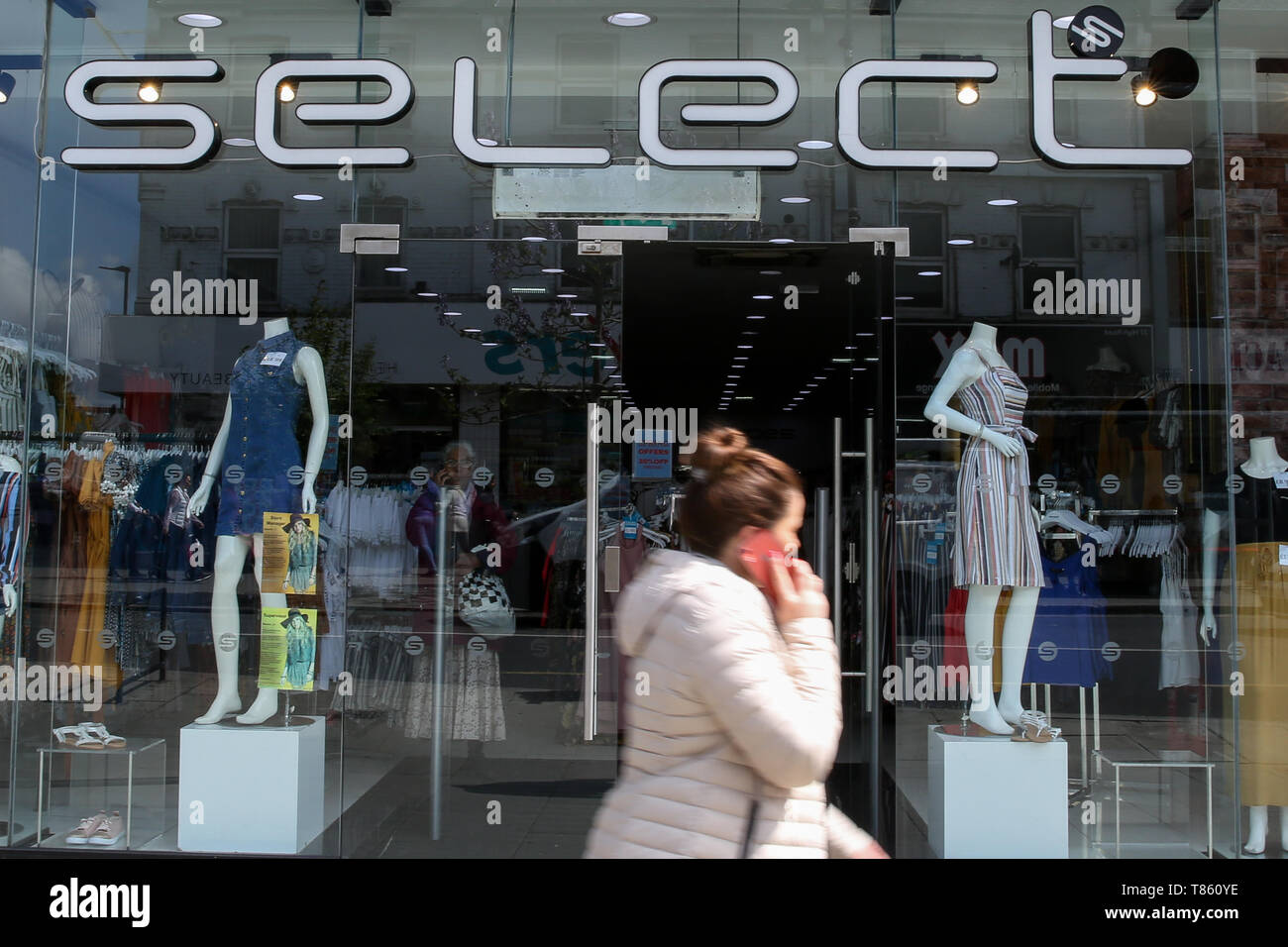 A shopper is seen walking past Select fashion chain store in north London. Select enters into administration, putting 1,800 jobs at risk. There are 169 Select stores across the UK and is owned by Turkish entrepreneur Cafer Mahiroglu. Stock Photo