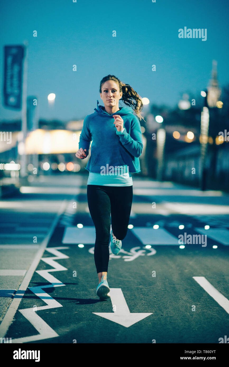 Woman jogging in city at night Stock Photo