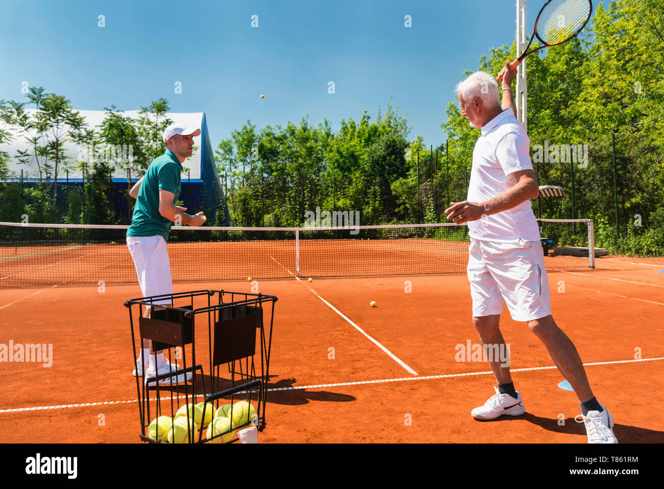Senior man with tennis instructor Stock Photo - Alamy