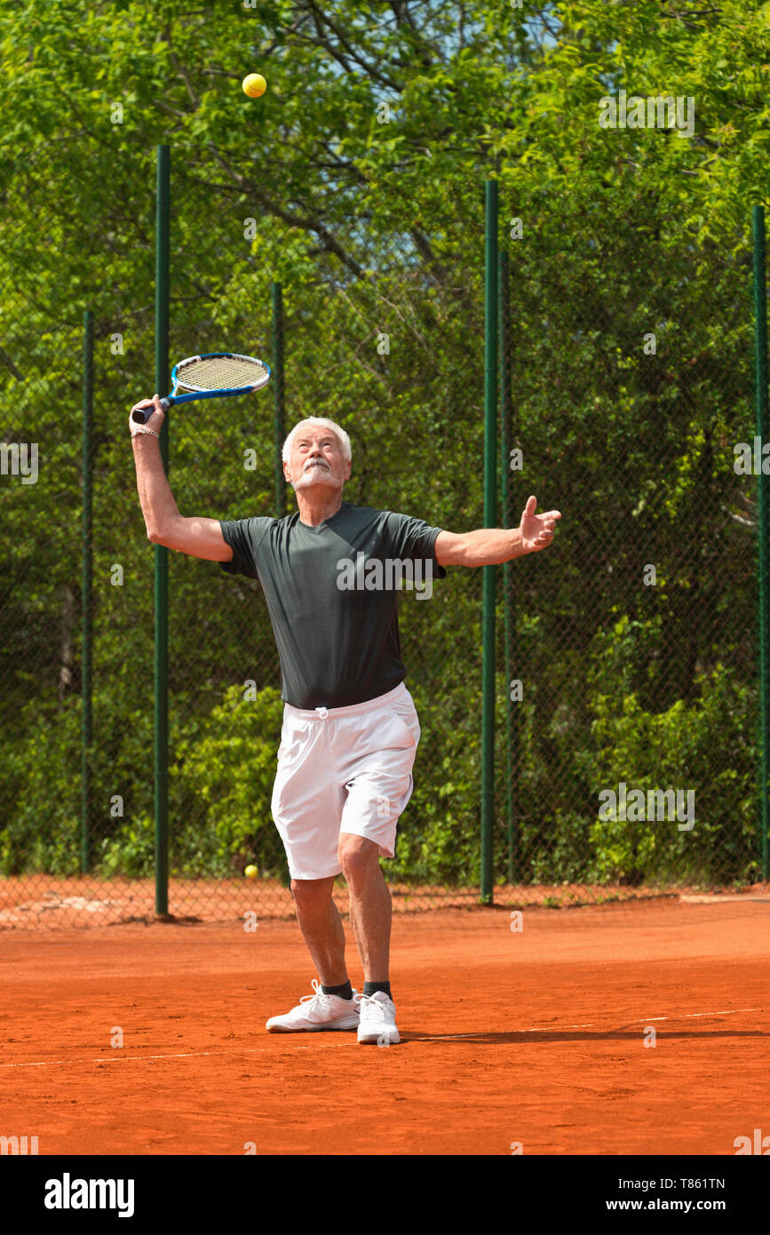 Active senior man playing tennis Stock Photo