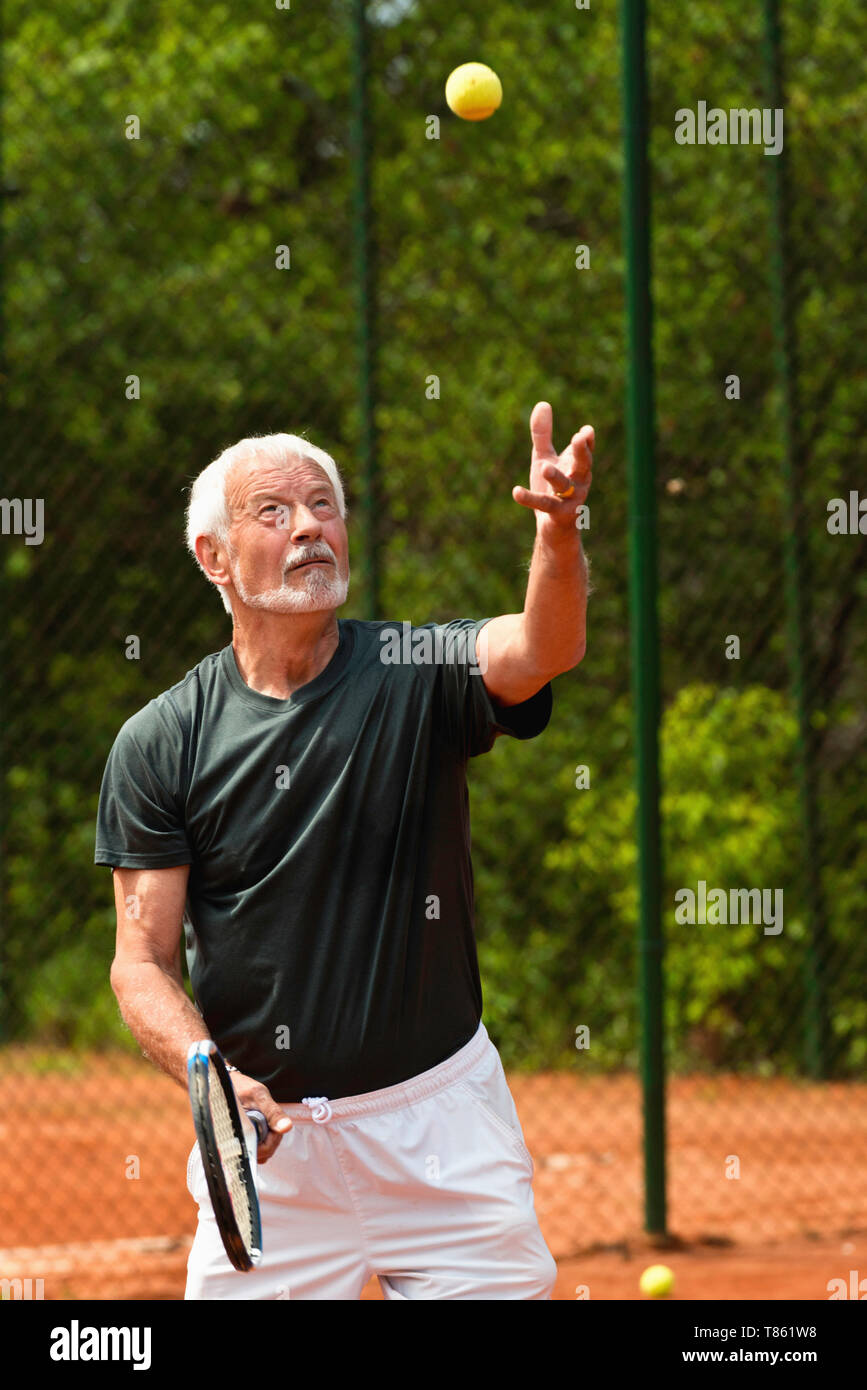 Active senior man playing tennis Stock Photo