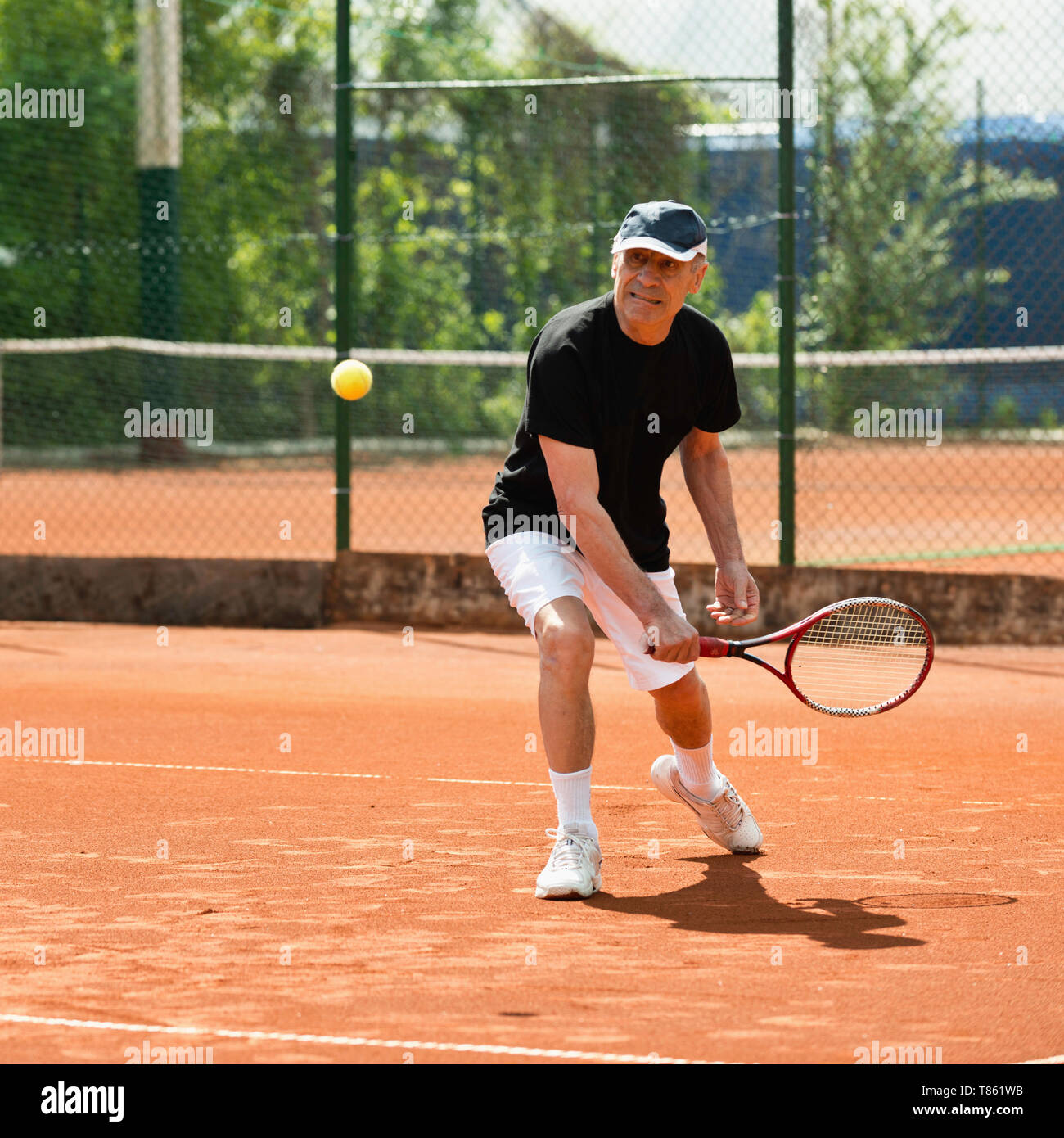 Active senior man playing tennis Stock Photo