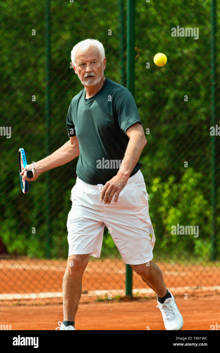 Active senior man playing tennis Stock Photo