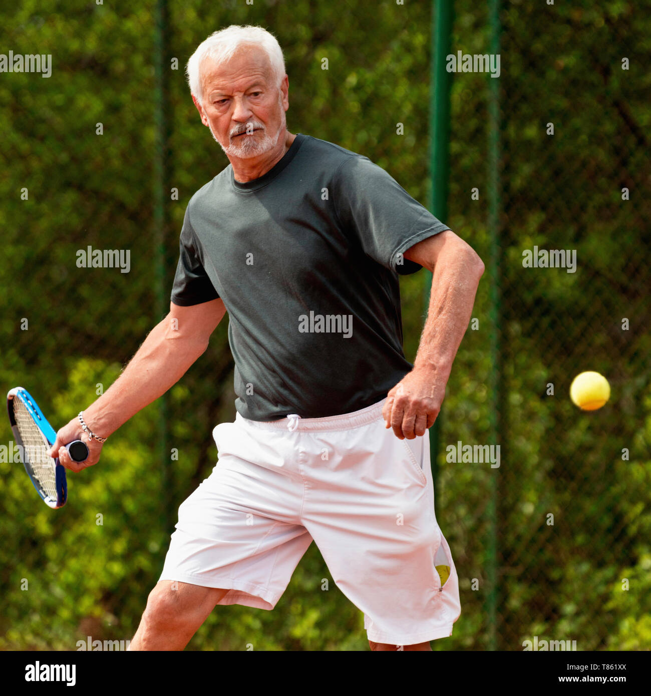 Active senior man playing tennis Stock Photo