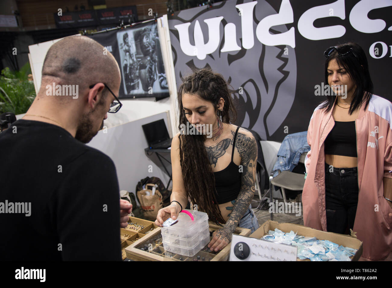 A tattoo artist seen selling tattoo products to customers during the