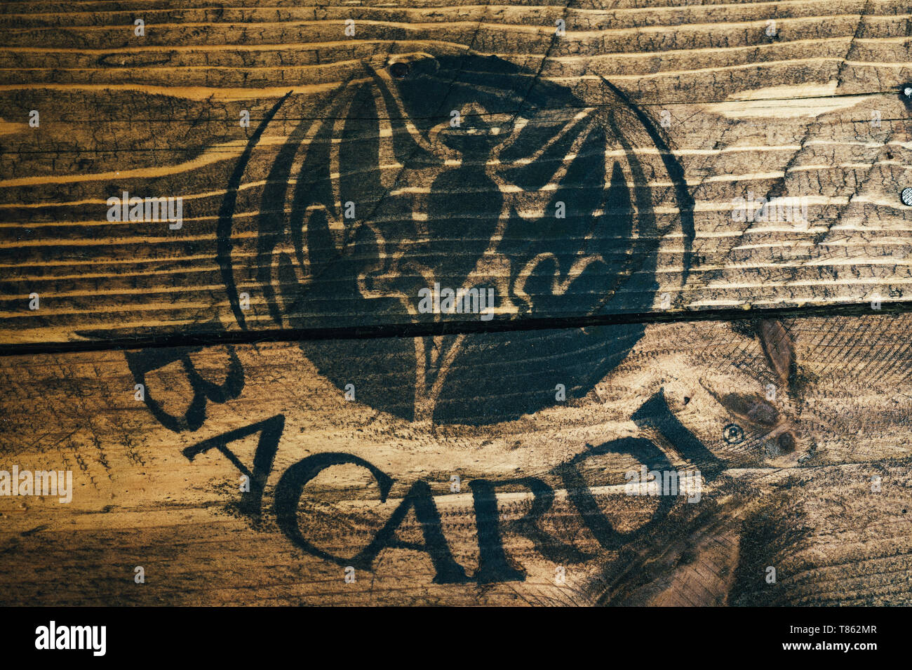 Black Bacardi white rum logo painted on rustic weathered wood Stock Photo