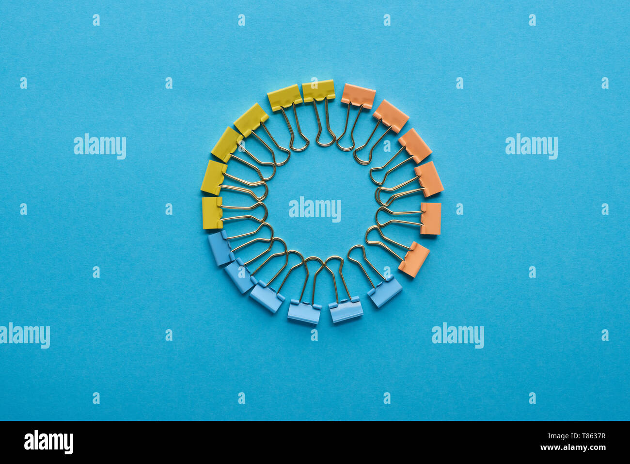 top view of paper clips arranged in round shape isolated on blue Stock Photo