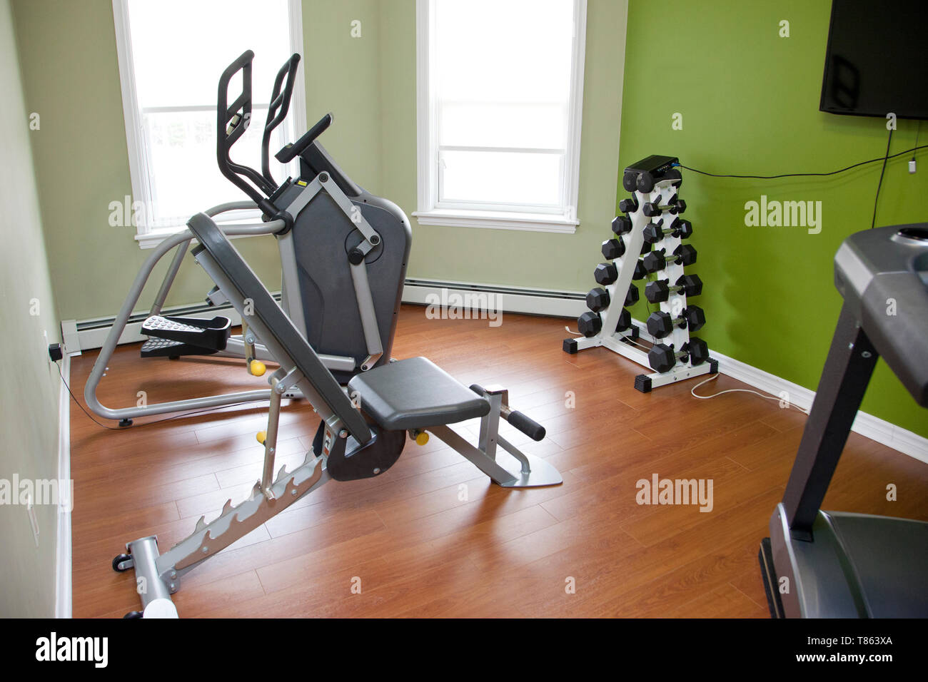 A Small Workout Room Inside An Apartment Or House With Bench