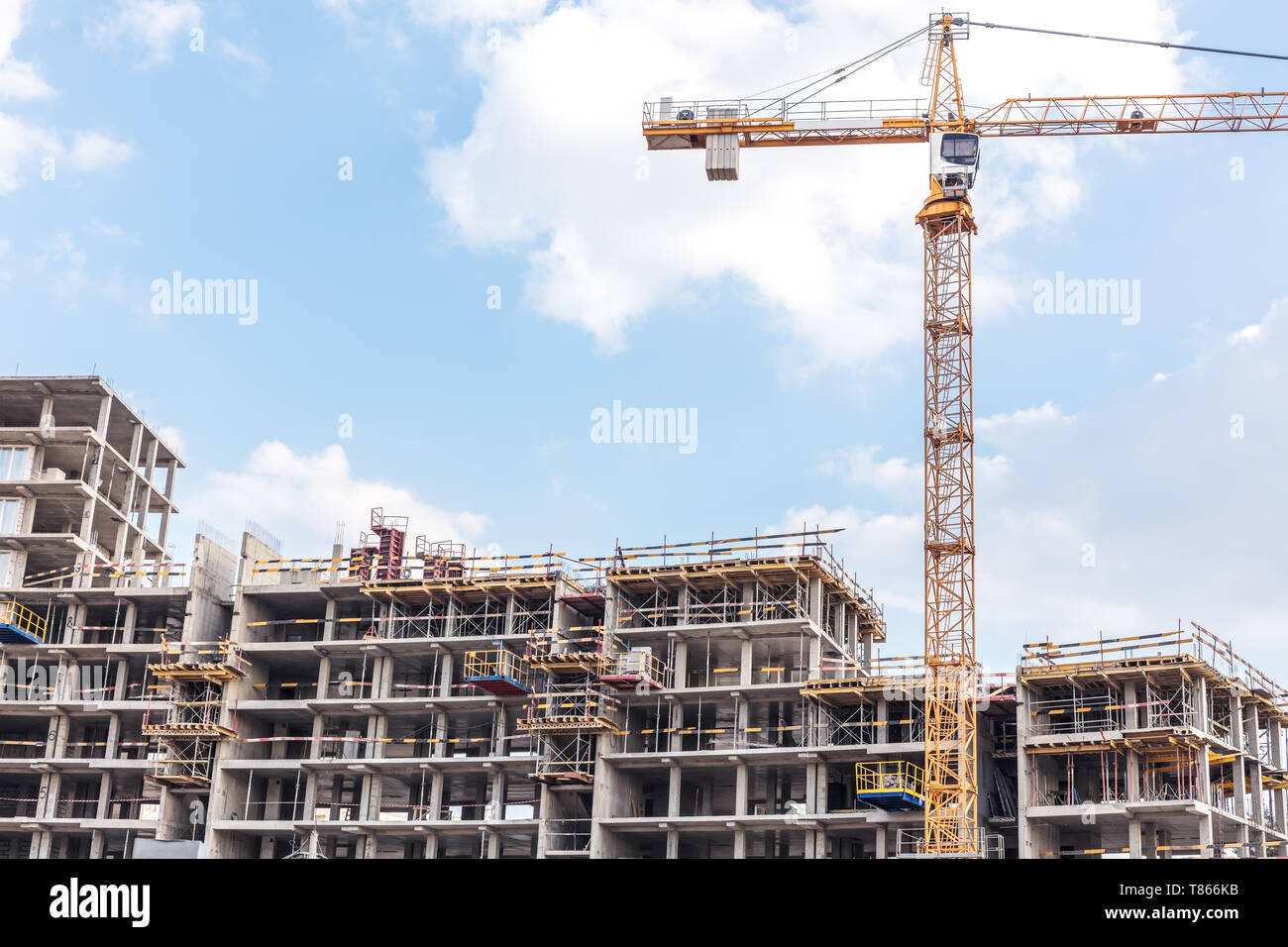 apartment building under construction with scaffolding. yellow tower ...