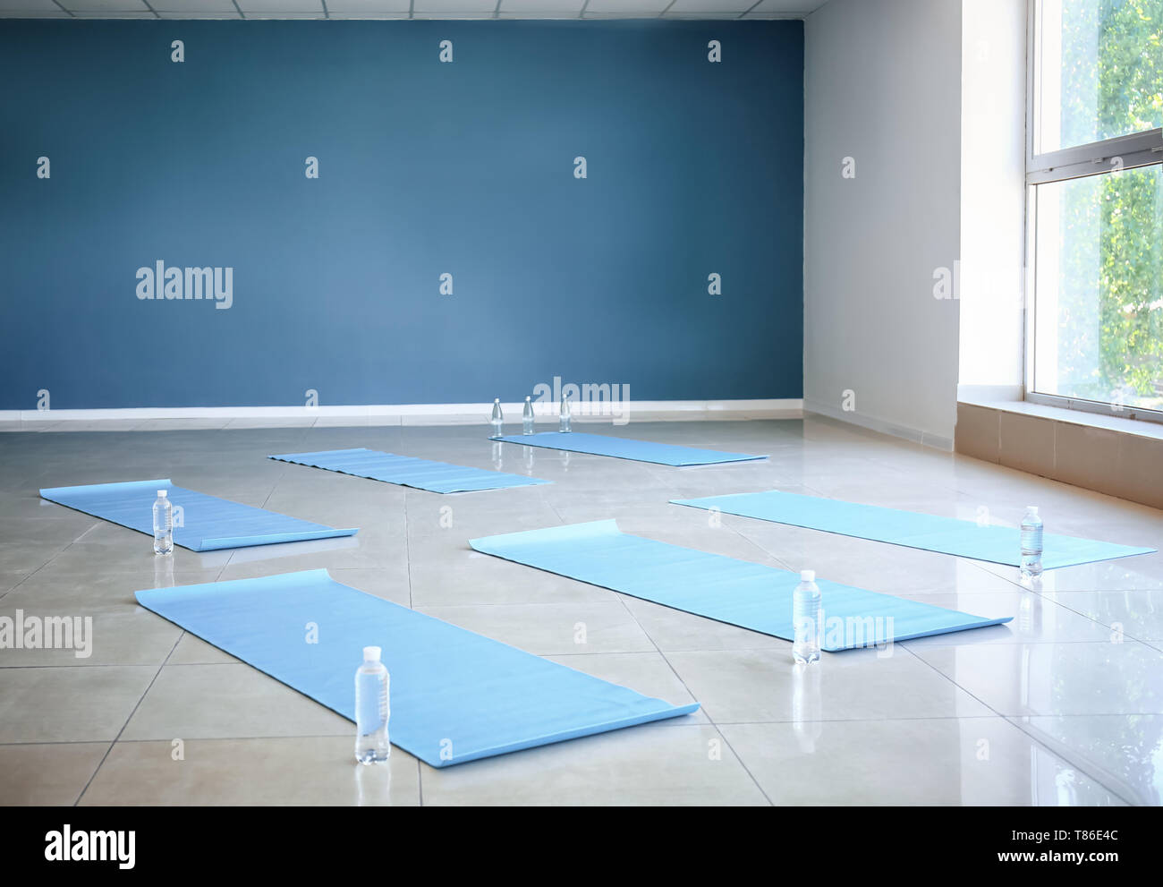 Yoga mats and bottles of water on floor in gym Stock Photo - Alamy