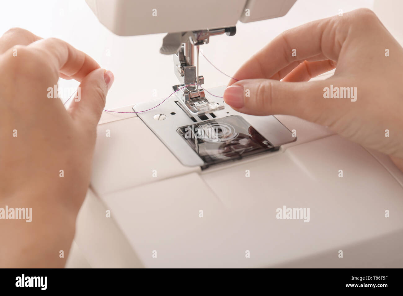 Female tailor threading sewing machine, closeup Stock Photo - Alamy