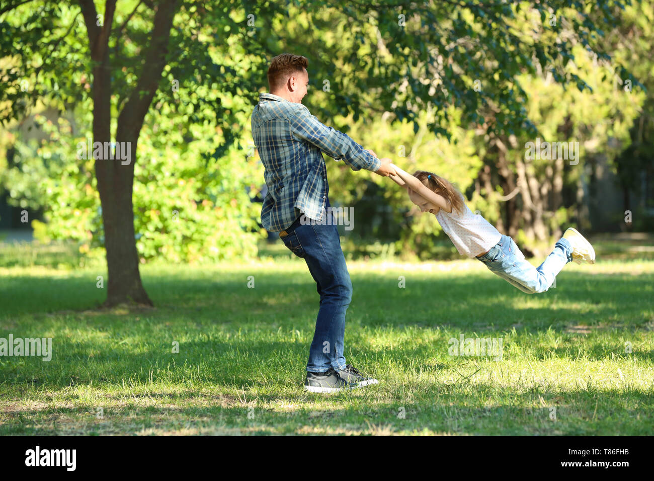 Happy father and daughter playing in green park Stock Photo - Alamy