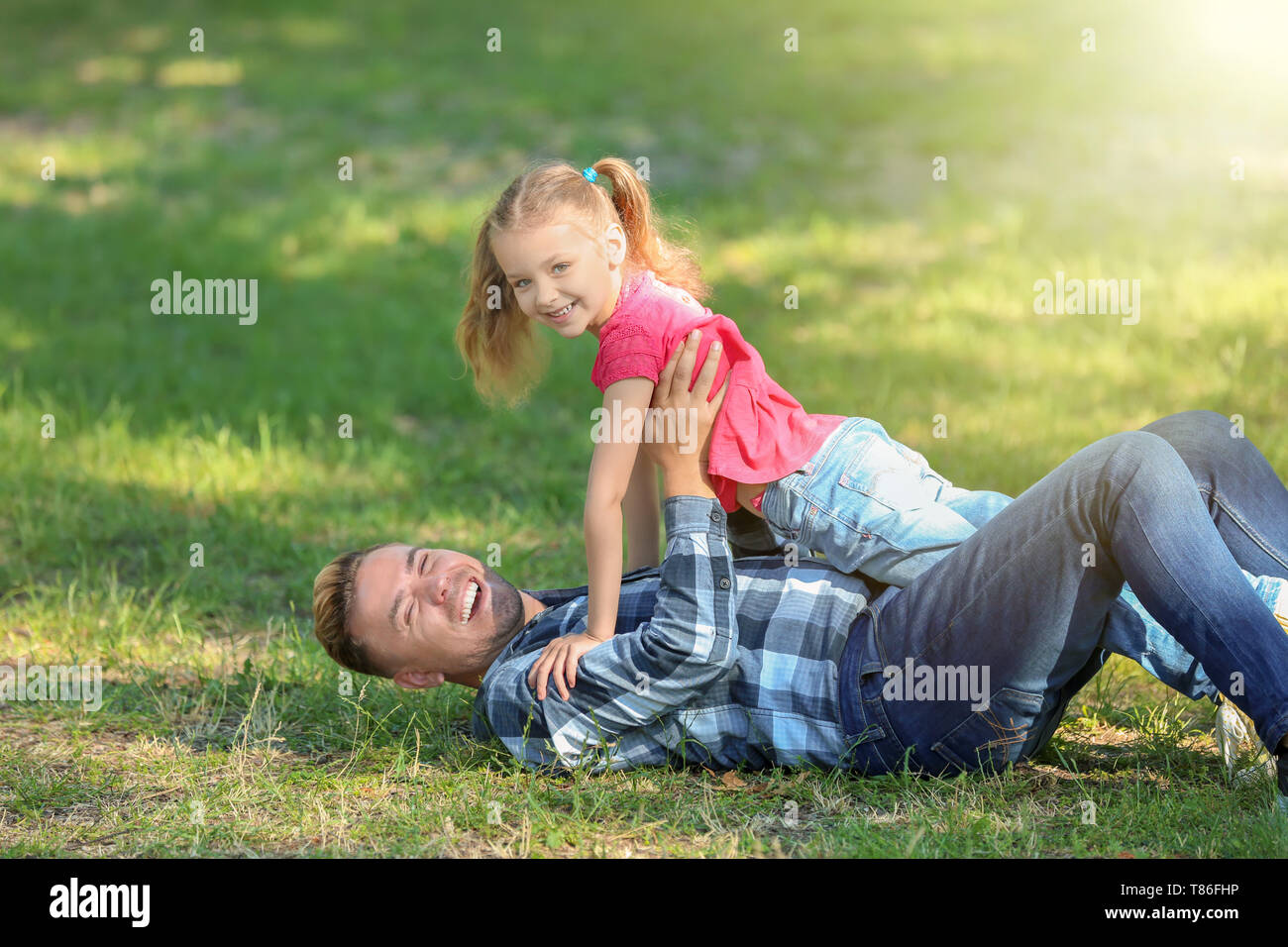 Happy father and daughter playing in green park Stock Photo - Alamy