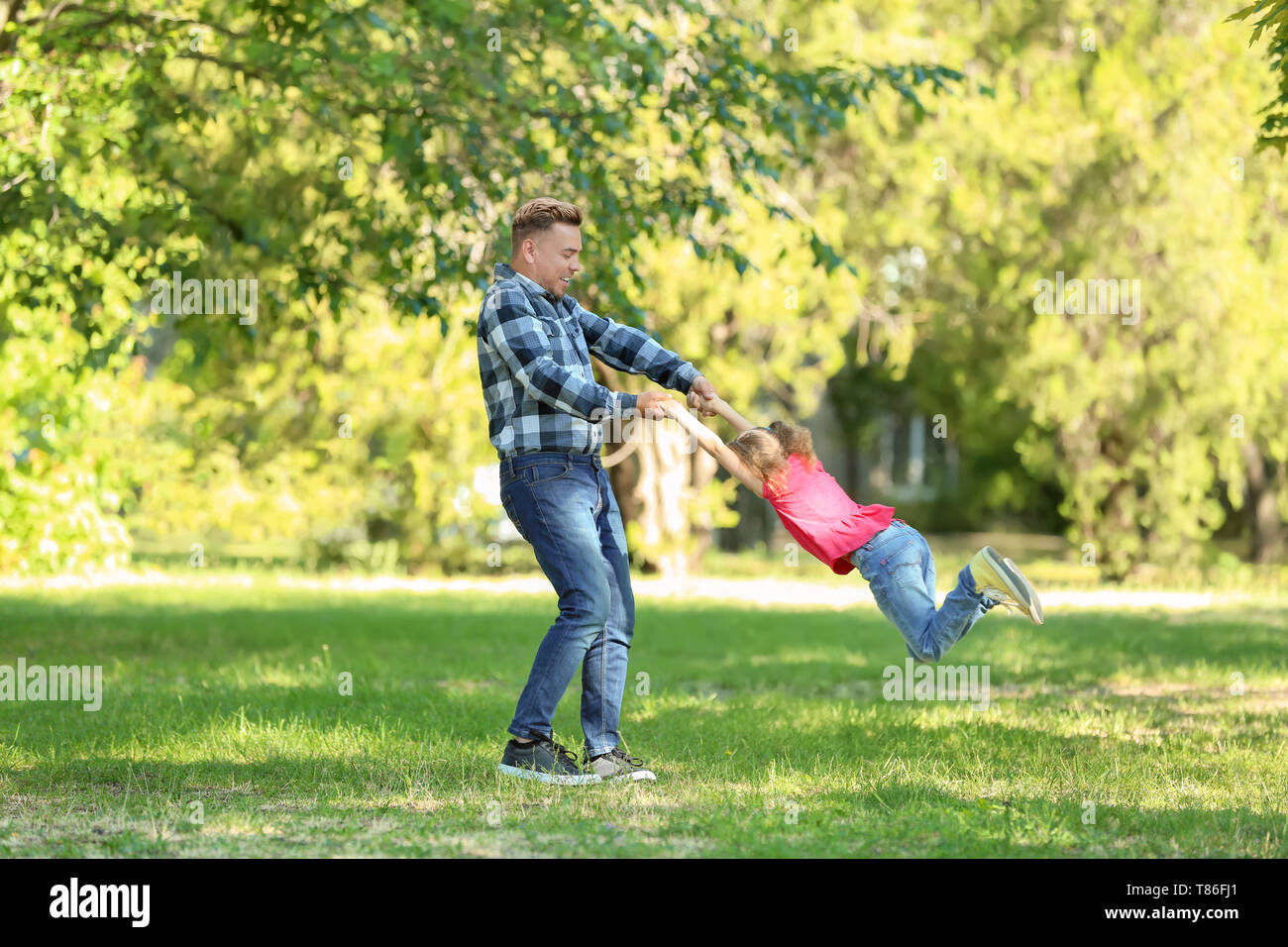Happy father and daughter playing in green park Stock Photo - Alamy