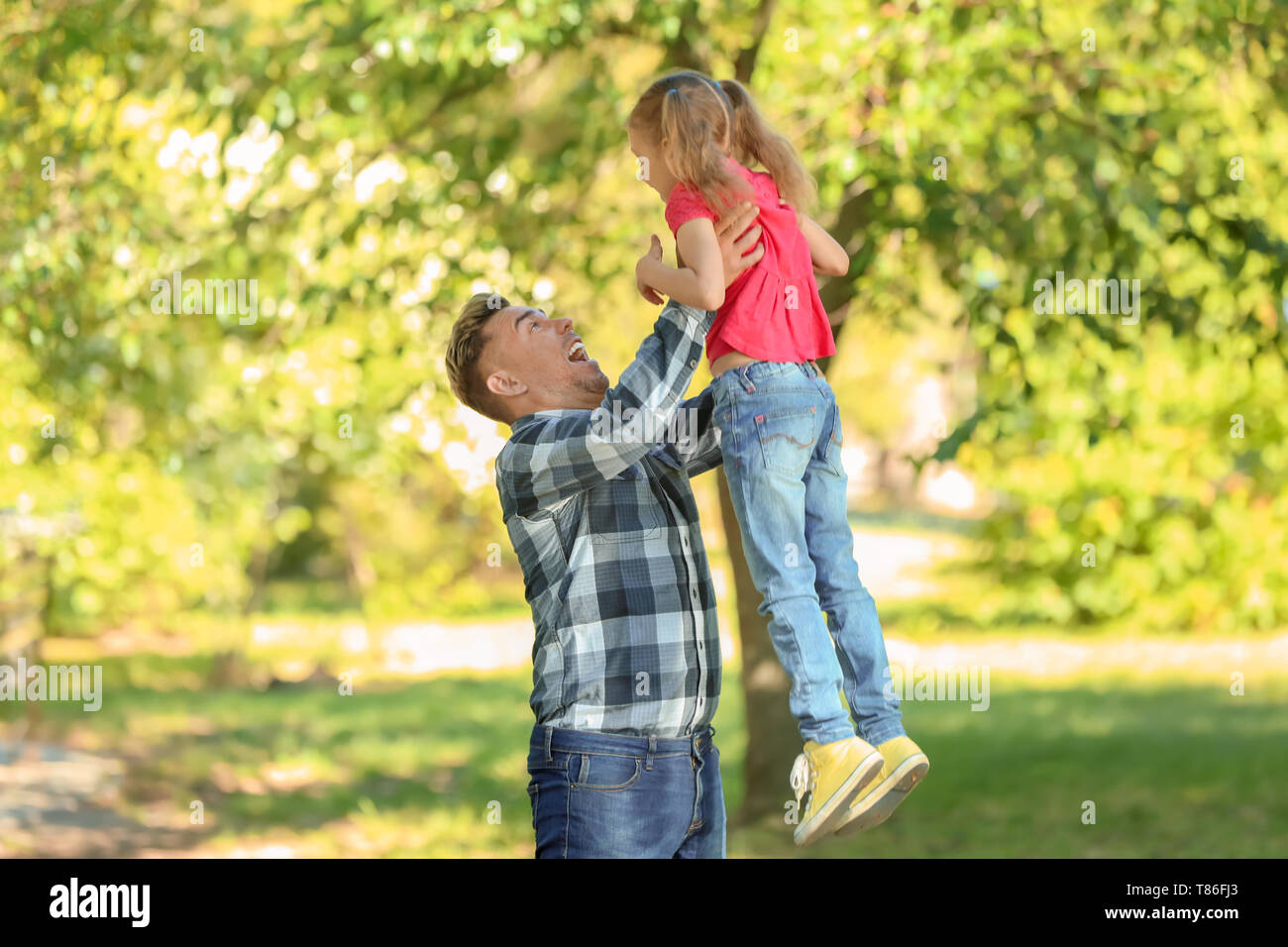 Happy father and daughter playing in green park Stock Photo - Alamy