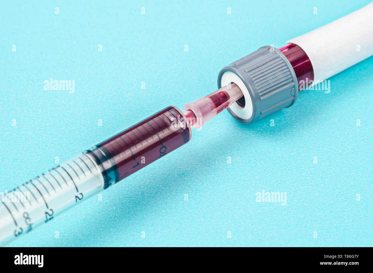 Blood sample in syringe and blood tube in laboratory background Stock ...