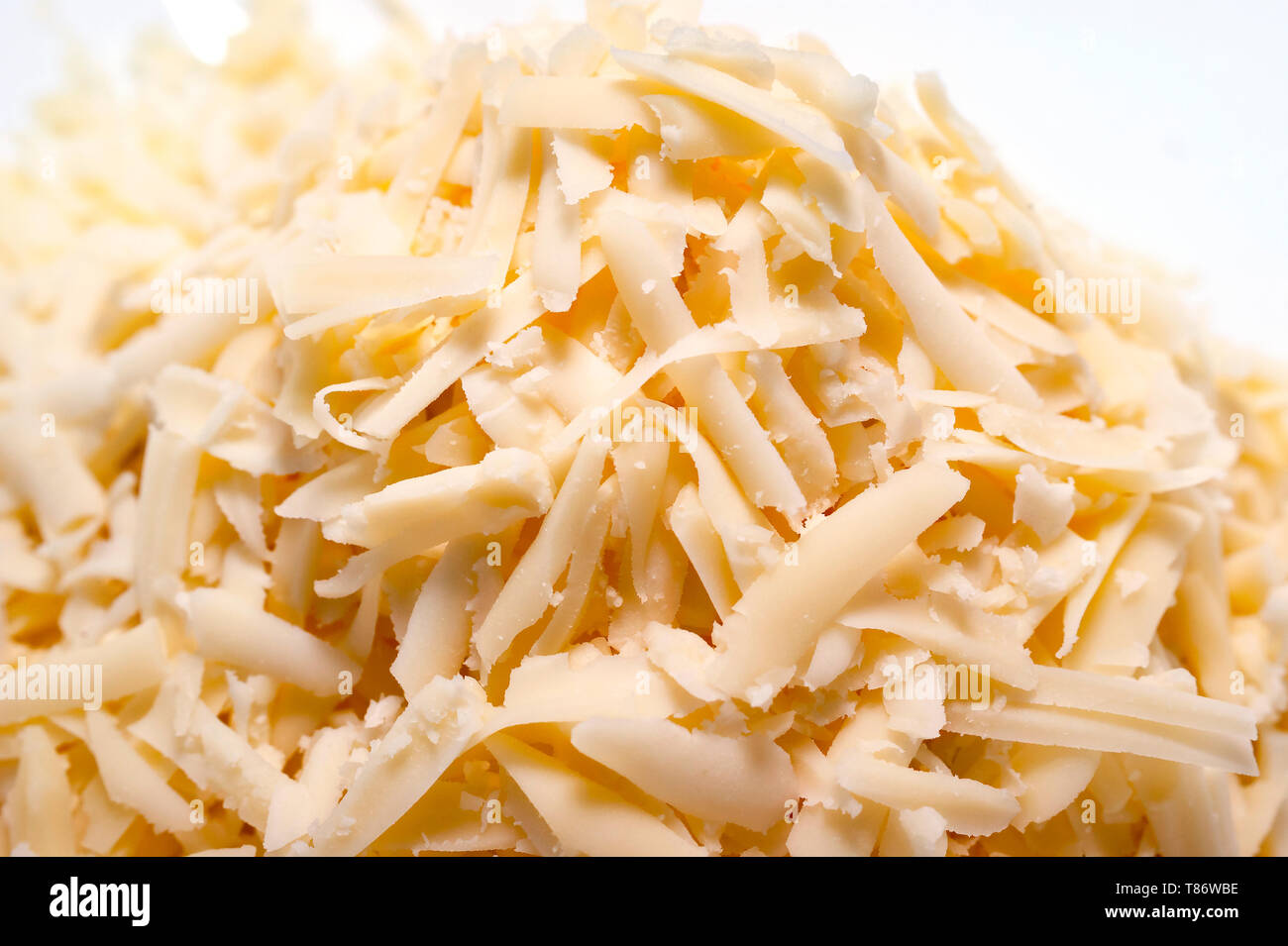 Pile of Grated Cheese on White Background. Organic Farming Dairy Products. Stock Photo