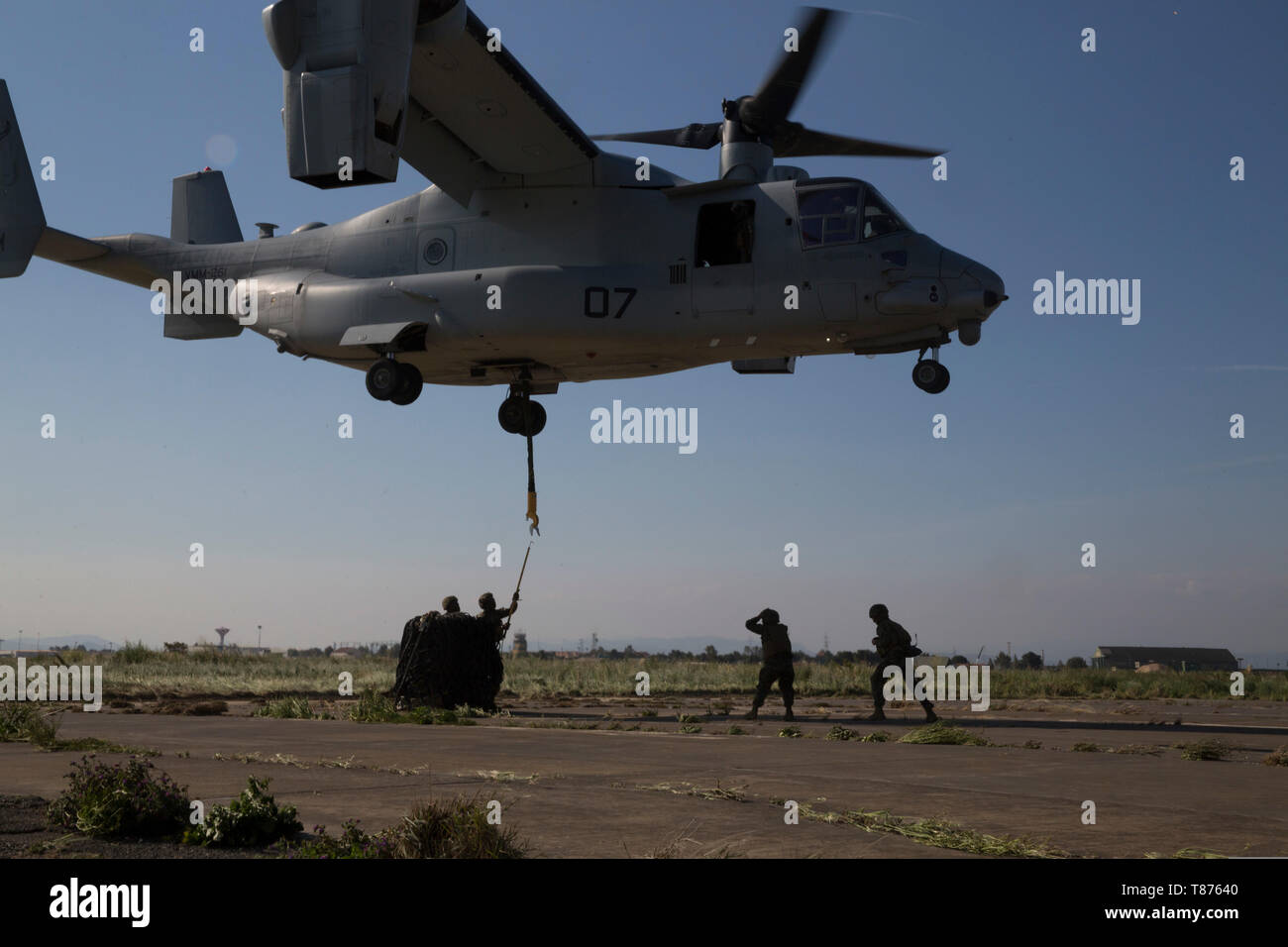 U.S. Marines with Special Purpose Marine Air-Ground Task Force-Crisis Response-Africa 19.2, Marine Forces Europe and Africa, reach for a cargo hook under a U.S. Marine Corps MV-22B Osprey during external-lift training at Naval Air Station Sigonella, Italy, April 18, 2019. SPMAGTF-CR-AF is deployed to conduct crisis-response and theater-security operations in Africa and promote regional stability by conducting military-to-military training exercises throughout Europe and Africa. (U.S. Marine Corps photo by Staff Sgt. Mark E. Morrow Jr. ) Stock Photo