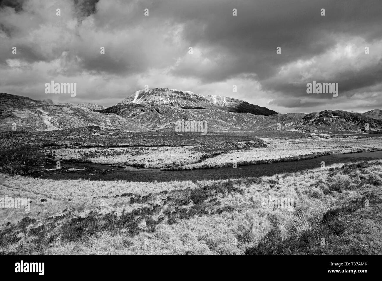 Snow-capped Arkle with River Laxford in foreground, Stormy April weather Reay Forest Estate, Sutherland Scottish Highlands UK. Stock Photo