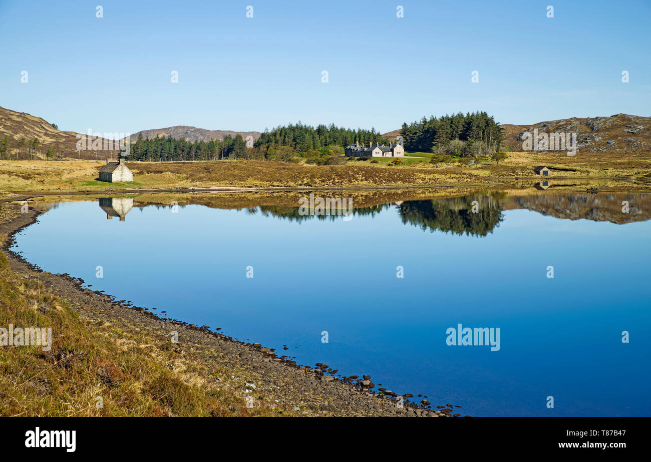 Stack Lodge on the Reay Forest estate seen from Loch Stack, Sutherland, Scottish Highlands UK, beautiful calm spring morning, reflections on loch. Stock Photo
