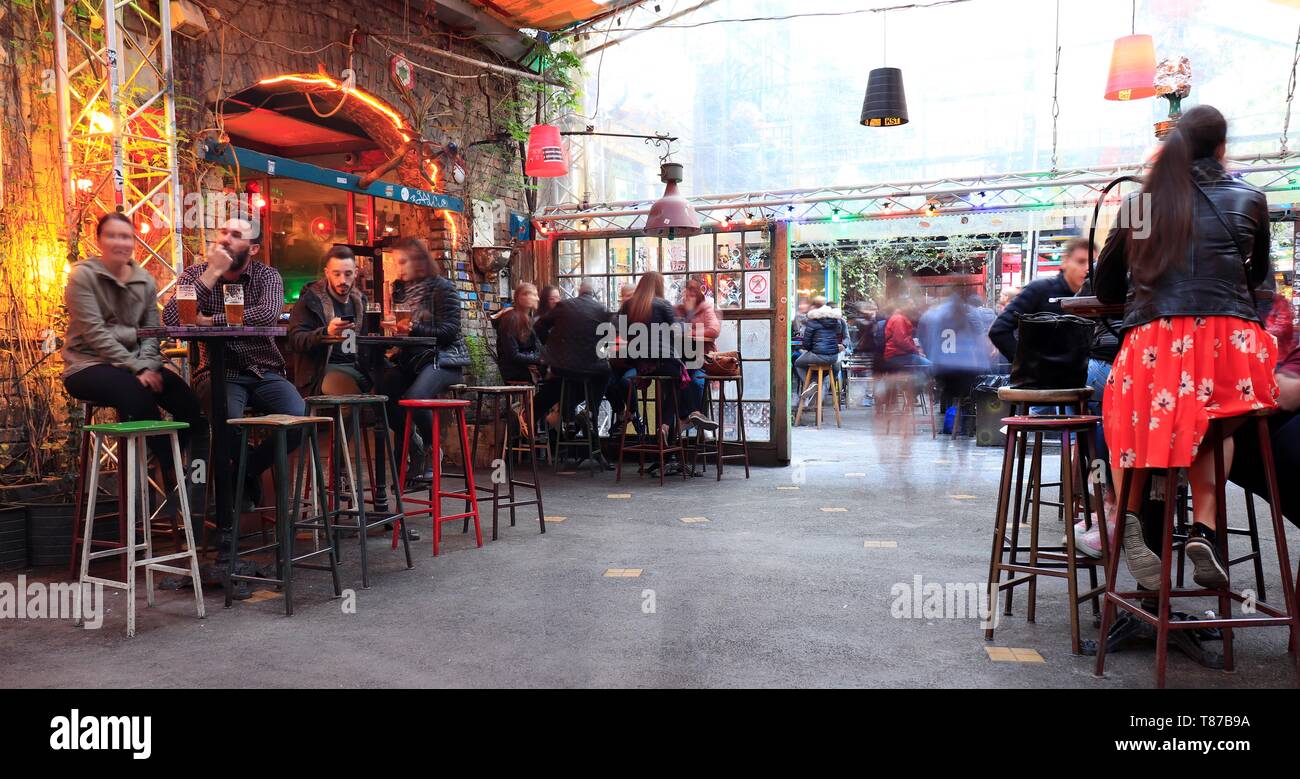 BUDAPEST, HUNGARY - april 2019: Interior view of the famous Szimpla Garden ruin pub with people sitting at table enjoying night life. Stock Photo